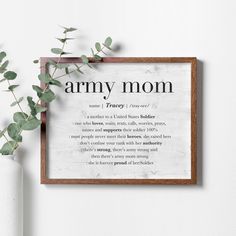 a framed army mom poem on a white wall next to a vase with greenery