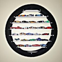 a circular display with cars on it in the middle of a white walled wall behind a black tire