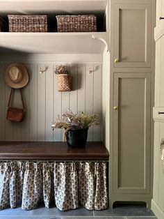 a wooden bench sitting under a window next to a shelf with baskets on top of it