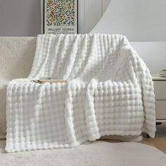 a white blanket on top of a bed in a room