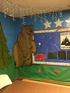 there is a bulletin board with a bear on it in the room that has been decorated