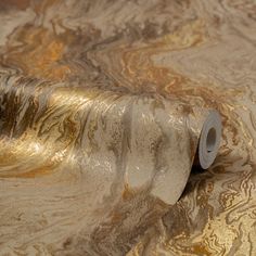 a roll of toilet paper sitting on top of a gold and silver surface