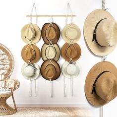 hats are hanging on the wall in front of a wicker chair