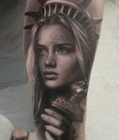 a woman's arm with a statue of liberty tattoo on it