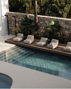 an outdoor pool with lounge chairs next to it