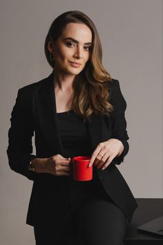 a woman is holding a red cup in her hand