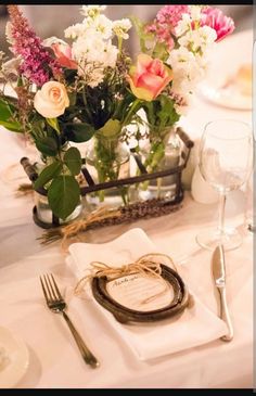 the table is set with flowers and place settings