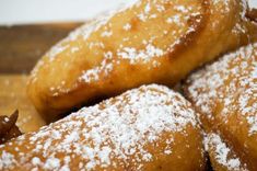 powdered sugar covered donuts piled on top of each other