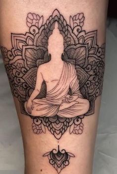 a woman's leg with a buddha tattoo on it