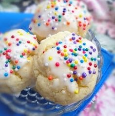 cookies with white frosting and sprinkles on a blue plate