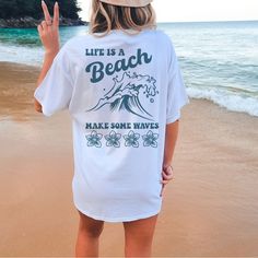 Tshirt Is Soft And Unisex Sizing For Loose Fit. For A Tighter Fit Size Down One. Life Is A Beach So Make Some Waves Design On Back Of White Tshirt And Front Pocket Has Make Some Waves Design. Beachy T Shirts, White Vsco T-shirt With Text Print, White Summer T-shirt With Text Print, White Pre-shrunk T-shirt For Loungewear, White Vsco Tops With Text Print, White Text Print Vsco Top, Summer Slogan T-shirt For Loungewear, White Vsco Style Top With Letter Print, White Vsco Top With Letter Print