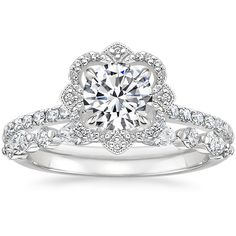 a white gold engagement ring set with round diamonds on the band and an intricate flower design