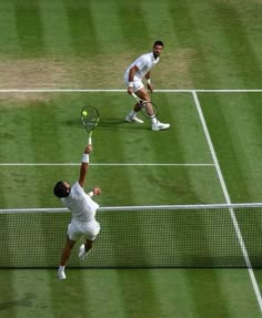 two men playing tennis on a grass court