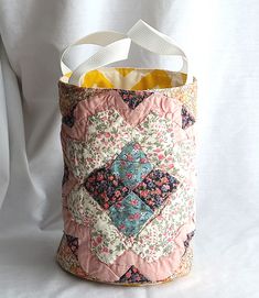 a bag made out of quilts and fabric on a white cloth covered tablecloth