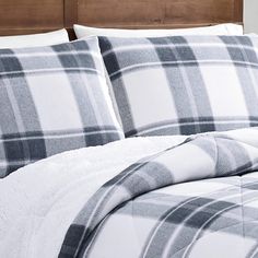 a plaid comforter and pillows on a bed