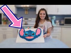 a woman is holding up a cake with an image of stitchy mouse on it