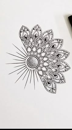 a drawing of a flower on paper next to a pen