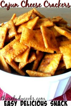 a white bowl filled with cheesy crackers on top of a red and white checkered table cloth