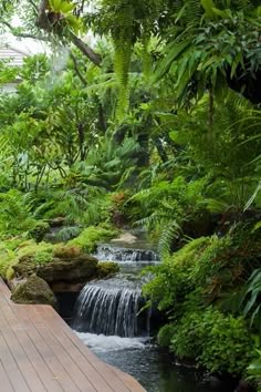 a wooden walkway leading to a small waterfall