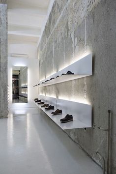 there are many shoes lined up on the shelves in this room and one is empty