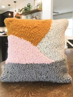 a cushion made out of knitted material sitting on top of a wooden table