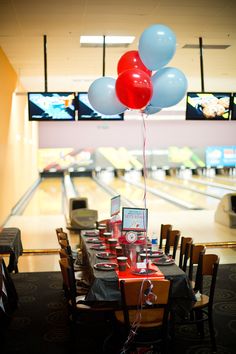 a bowling alley filled with tables and balloons