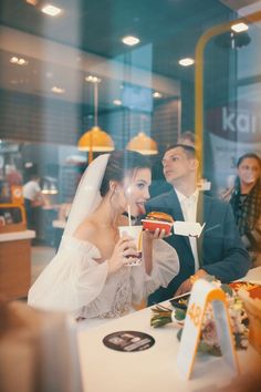 a bride and groom eating food at a restaurant