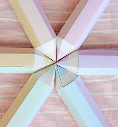 an origami style object is shown in the middle of pink and white stripes