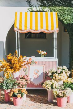 an ice cream stand with flowers and potted plants