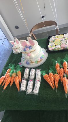 a table with carrots, cake and bunnies on it