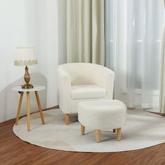 a white chair and footstool in front of a curtained window with curtains