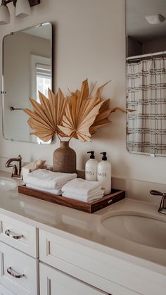 a bathroom with a sink, mirror and towels on the counter in front of it