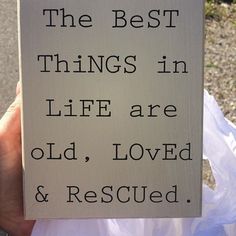 a hand holding a sign that says the best things in life are old, loved and rescued