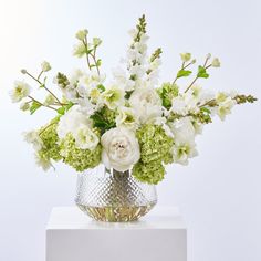 a vase filled with white and green flowers