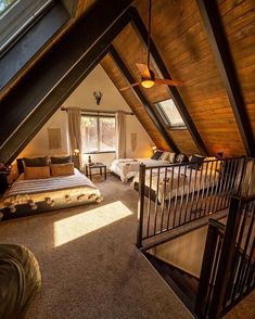 an attic bedroom with two beds and a loft