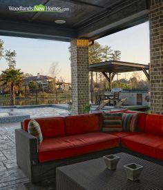 a red couch sitting on top of a patio next to a swimming pool