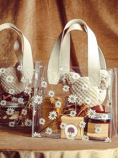 two clear bags sitting on top of a table next to each other with small items in them