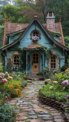 a blue house with lots of flowers around it