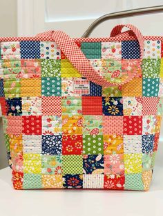 a multicolored patchwork bag sitting on top of a white counter next to a door