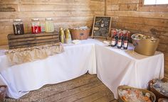 a table with food and drinks on it in front of a wooden paneled wall