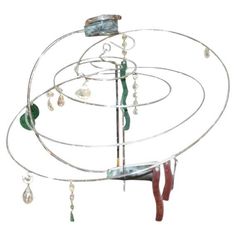 a circular metal object with beads hanging from it's sides and on the top