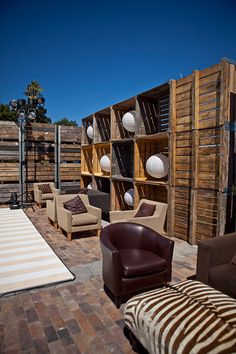 a living room filled with lots of furniture next to a wooden wall covered in white balls