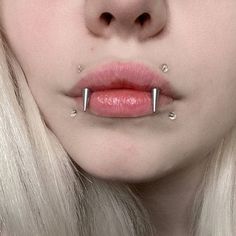 a woman with piercings on her nose is wearing pink lipstick and white hair,