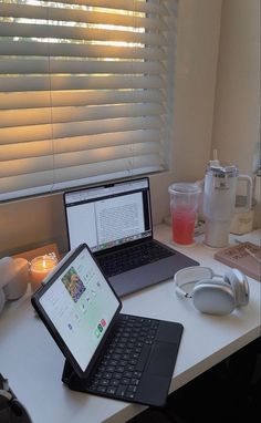 an open laptop computer sitting on top of a white desk