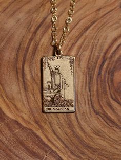 the magician tarot card necklace on a wooden surface