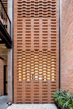 a brick wall with wooden slats on the side and planters in front of it