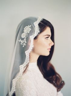 a woman wearing a veil with flowers on it