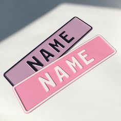 two pink name tags with the word name on them