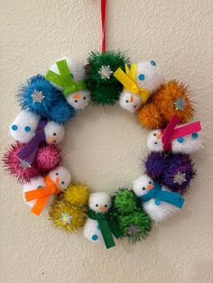 a wreath made out of pom - poms hanging on the wall