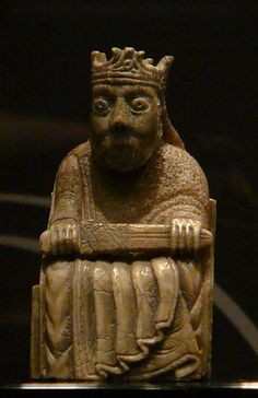 an old statue with a crown on it's head sitting in front of a black background